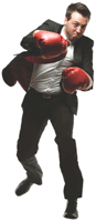 Guy in business suit wearing boxing gloves standing in boxing pose